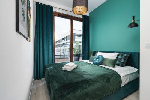 Prime Apartments في وارسو: غرفة نوم بسرير والجدران الزرقاء ونافذة