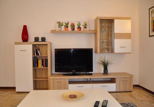 una sala de estar con TV en un centro de entretenimiento de madera en La Casa di Sarita, en Pavia