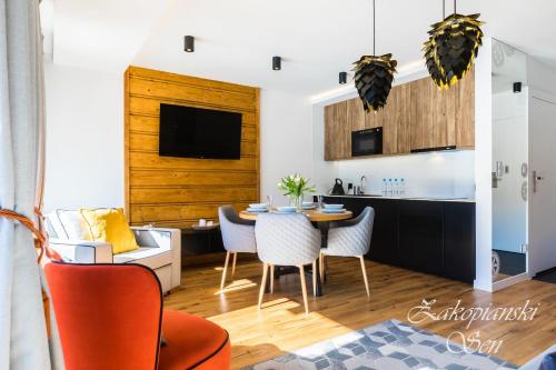 a kitchen and dining room with a table and chairs at Rezydencja Zakopiańska in Zakopane
