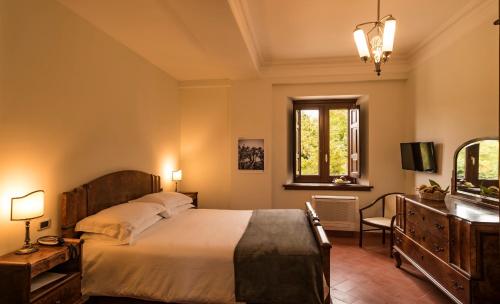 a bedroom with a bed and a dresser and a window at Il Mulino della Signora Luxury country House in Frigento