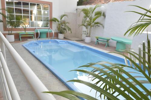 una piscina en un balcón con plantas y bancos en Hospedaje Villa Naloy, en Santa Marta