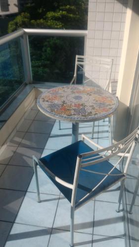 a table and two chairs on a balcony with a table and chairs at Apart Hotel Quartier Latin in Vitória