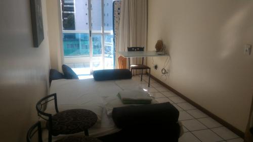 a living room with a couch and a table and a window at Apart Hotel Quartier Latin in Vitória