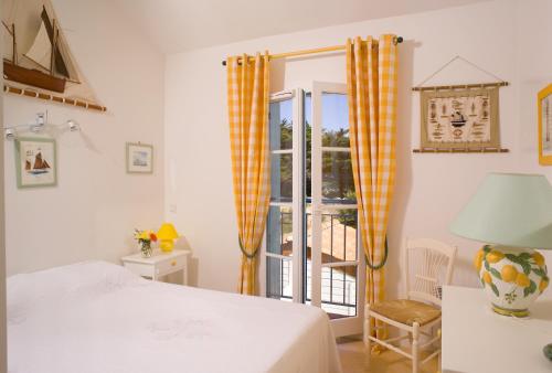 a bedroom with a bed and a window with a balcony at Madame Vacances Les Maisons du Lac in Saint-Jean-de-Monts