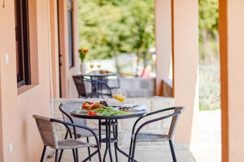 a table with chairs and a plate of food on a balcony at Apartments Barbara in Kotor