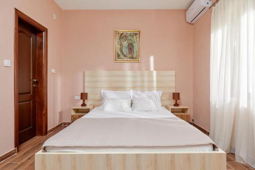 a bedroom with a large bed with white sheets and pillows at Apartments Barbara in Kotor