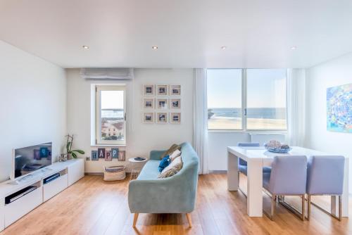 a white living room with a table and chairs at João Beach House in Leça da Palmeira
