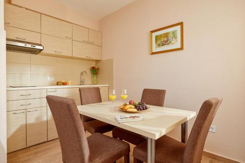 a dining room table with chairs and a bowl of fruit on it at Apartments Barbara in Kotor