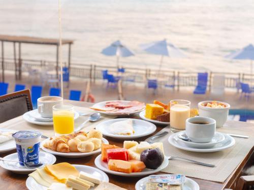 una mesa con platos de desayuno en la playa en Ocean Palace All Inclusive Premium, en Natal