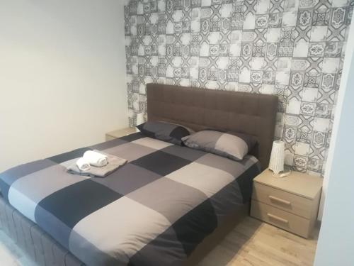 a bedroom with a bed with a blue and white comforter at Murena Apartments & rooms in Rome