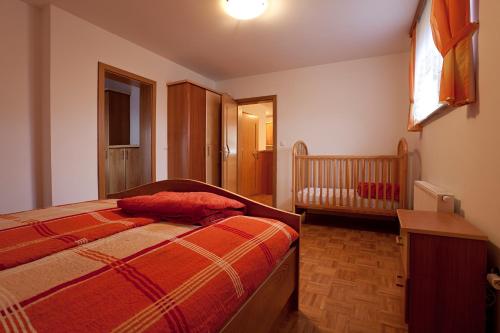a small bedroom with a bed and a crib at Tourist Farm Škrbina in Otočec