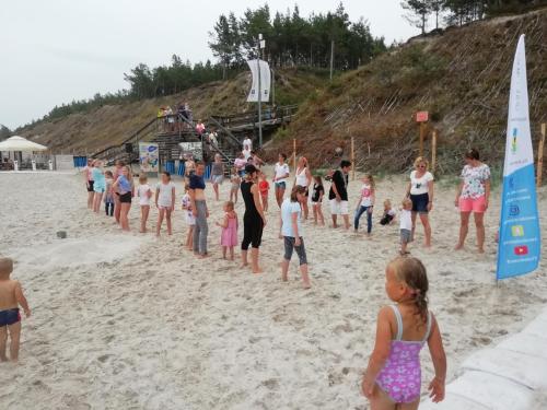 a group of people standing on the beach at Białka B in Białogóra