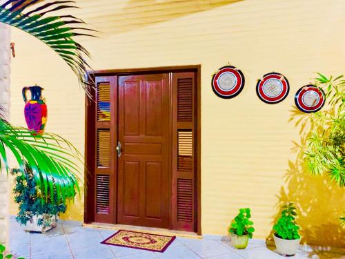 una casa con una puerta de madera y algunas plantas en Casa de Férias no Porto das Dunas, en Aquiraz