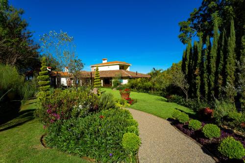 a garden with a house in the background at Villa Nogal Hotel Boutique & Vista in San Sebastián del Oeste