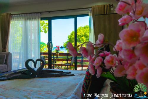 a bedroom with a bed with two scissors on it at Lipe Banyan Apartments in Ko Lipe