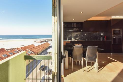 a kitchen with a view of the beach from a balcony at João Beach House in Leça da Palmeira