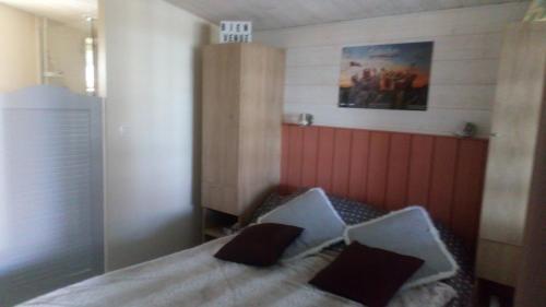 um quarto com uma cama com duas almofadas pretas em Le Petit Logis em Puy-du-Fou