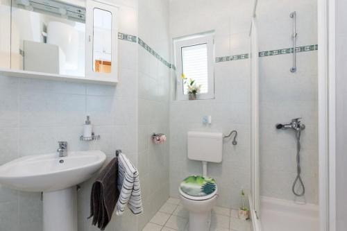 a bathroom with a sink and a toilet and a shower at Apartments in Vrbnik/Insel Krk 36771 in Vrbnik
