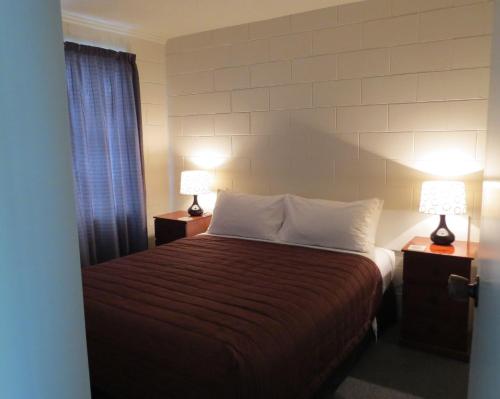 a bedroom with a bed with two lamps on night stands at Culverden Court Motel in Culverden
