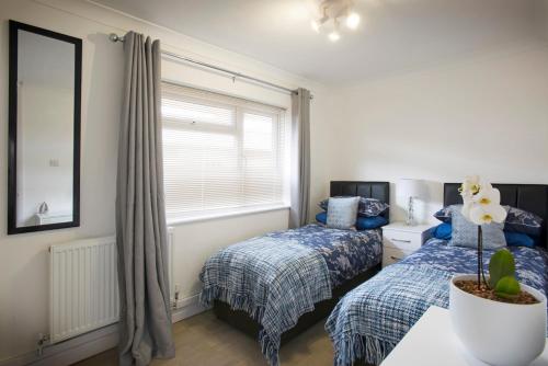 a bedroom with two beds and a window at Mae's Lodge in Birchington