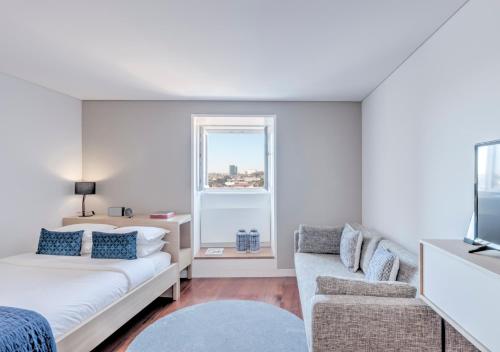 een woonkamer met een bank, een bed en een raam bij Oporto Street das Aldas - River View in Porto