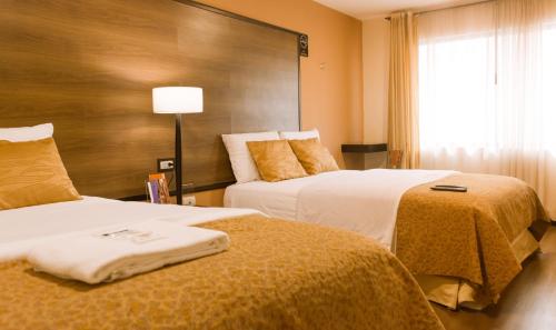 Habitación de hotel con 2 camas y ventana en Hotel La Farola en Cuenca