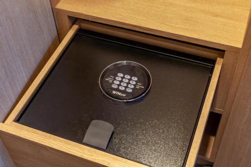 a tablet in a wooden box with a remote control at Ramada Encore by Wyndham Gimpo Han River Hotel in Gimpo
