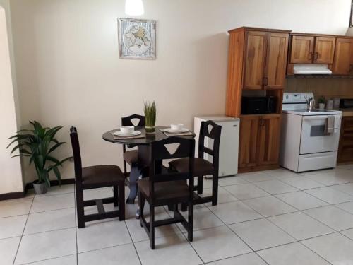 kuchnia ze stołem i krzesłami w pokoju w obiekcie Kubo Apartment w mieście Alajuela