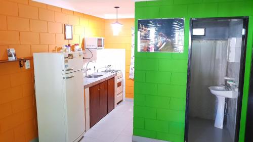 a green and white kitchen with a refrigerator and a sink at Residencia Jose Maria in Santa Rosa de Calamuchita