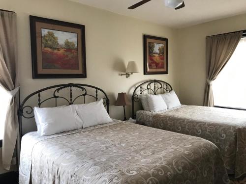 a hotel room with two beds and a window at Riverside Hot Springs Inn & Spa - Adults Only in Lava Hot Springs