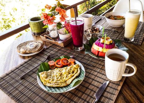 un tavolo con un piatto di cibo e una tazza di caffè di Villa Domanik a Labuan Bajo