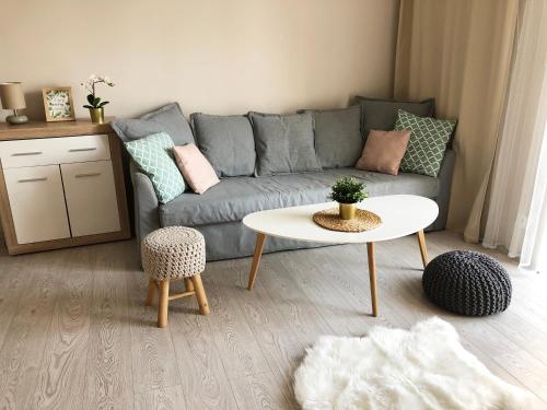ein Wohnzimmer mit einem Sofa und einem Tisch in der Unterkunft Ozarowska 77 - 1BR by Homeprime in Warschau