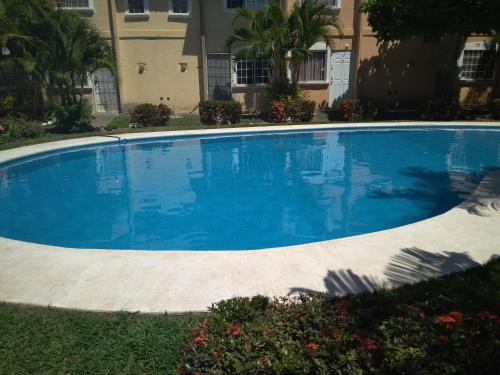 a large blue swimming pool in front of a building at Casa con alberca!! Ixtapa Zihuatanejo in Zihuatanejo