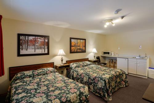 a hotel room with two beds and a kitchen at Oakwood Motel in Gravenhurst