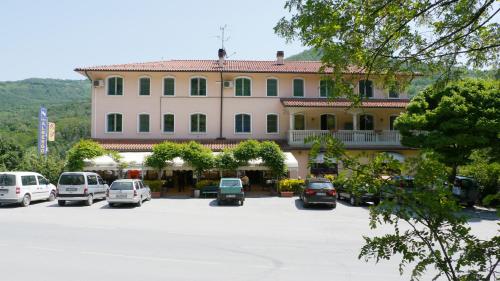 a large building with cars parked in a parking lot at Albergo Ristorante Sterlina in Grizzana