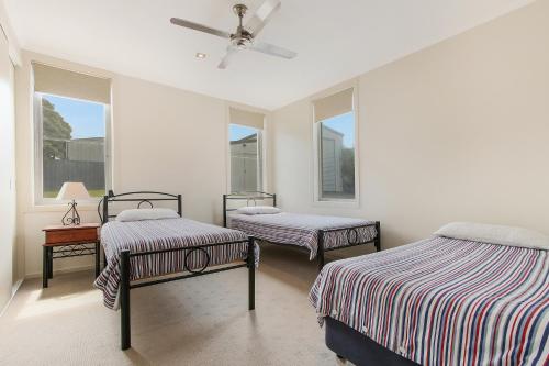 a bedroom with two beds and two windows at Nautilus in Lakes Entrance