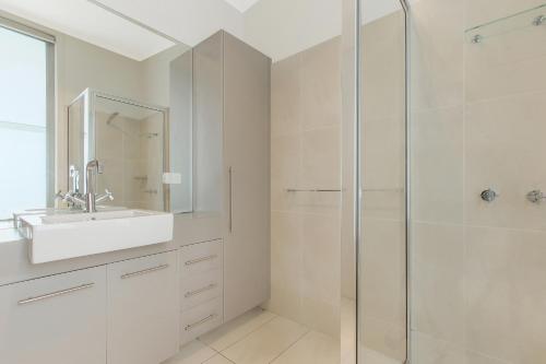 a white bathroom with a sink and a shower at Nautilus in Lakes Entrance