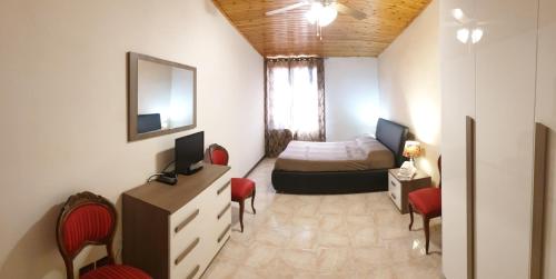 Habitación pequeña con cama, escritorio y sillas. en Cà Vivaldi penthouse 5terreparco, en Riomaggiore