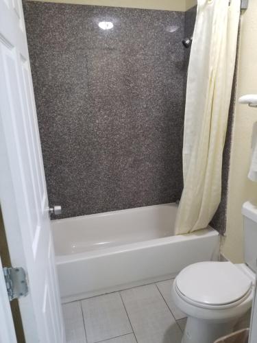uma casa de banho com um WC, uma banheira e um WC. em Economy Inn Motel em Orange