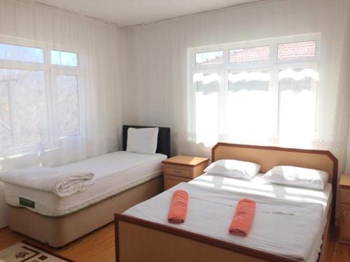 duas camas num quarto com duas janelas em Sehsuvar Peace Pension em Egirdir