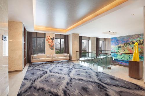 a lobby with a couch and a large rug at Ascott Sudirman Jakarta in Jakarta