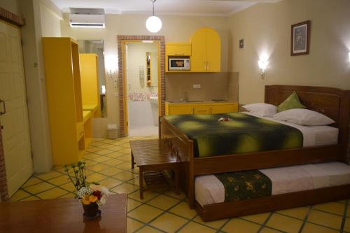 a bedroom with a large bed and a kitchen at Hotel Deli River and Restaurant Omlandia in Medan