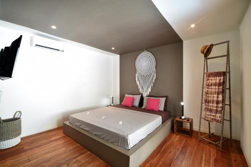 ein Schlafzimmer mit einem großen Bett mit rosa Kissen in der Unterkunft Meno Suites in Gili Meno