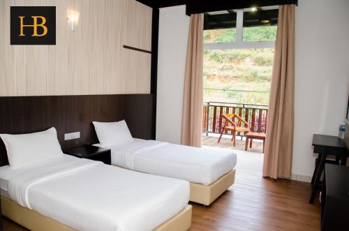 two beds in a hotel room with a balcony at H Benjamin Residence in Kampong Kundassan