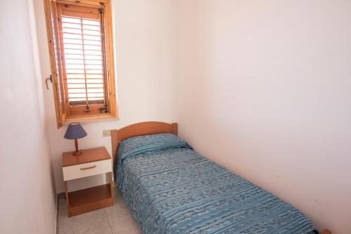 een kleine slaapkamer met een bed en een raam bij Studio 200 meters from the sea, wifi, self catering in Case San Marco