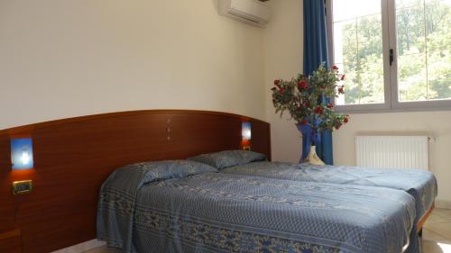 a bedroom with a bed and a vase of flowers at Albergo Ristorante Sterlina in Grizzana