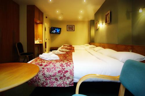 a hotel room with a large bed and a table at Westbury Hotel in London