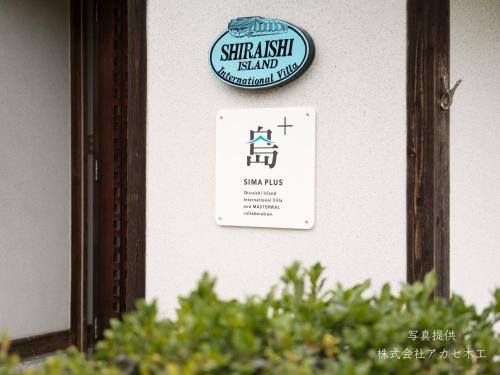 a sign for a small house on a wall at Shiraishi Island International Villa in Kasaoka