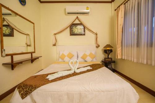 Family Resort Chumphon في شومفون: غرفة نوم بسرير عليها شريط ابيض