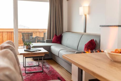 a living room with a couch and a table at Hotel Der Wastlhof - Pools, Spa & eigene Reitschule in Niederau